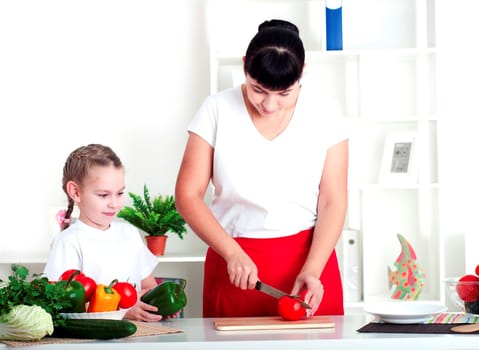 Mother and daughter cooking vegetable salad together