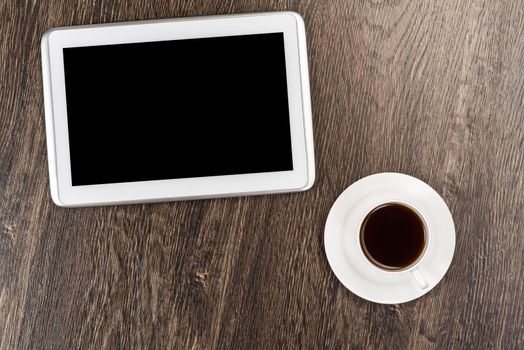 tablet and cup of coffee are on the table, still life