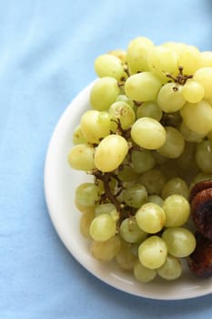 grapes on the plate on the blue background