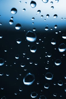 small water drops on the  window in the blue color