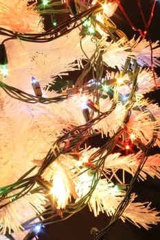 detail of xmas tree with color lights on the black background