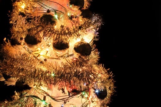 detail of xmas tree with color lights on the black background