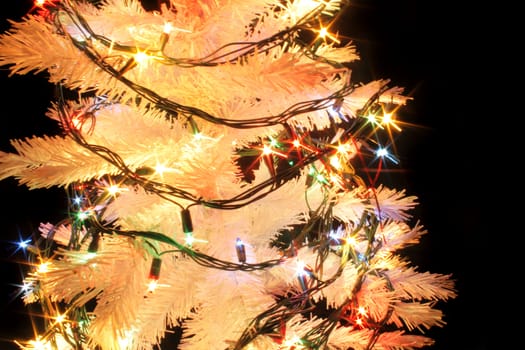 detail of xmas tree with color lights on the black background