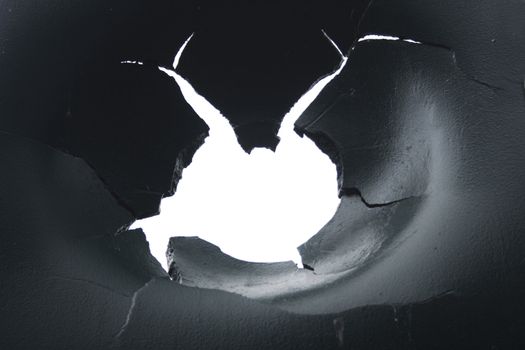 hole in the metal with white background behind it