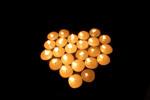 heart from the candles on the black background