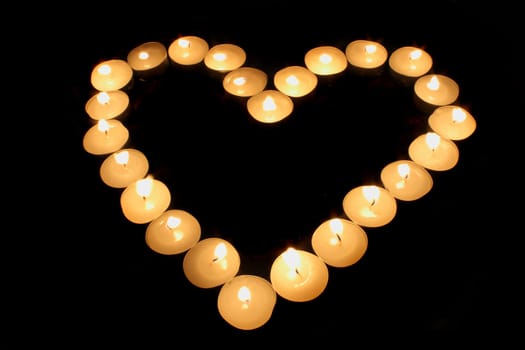heart from the candles on the black background