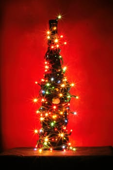 christmas alcohol bottle with color lights on black background