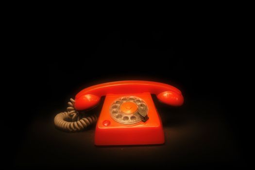 old orange phone isolated on the black background