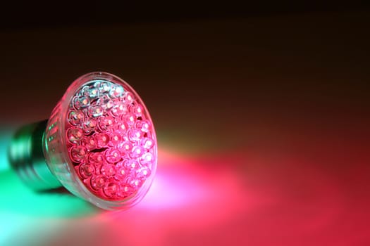 led lightbulb with green and red color in the dark night