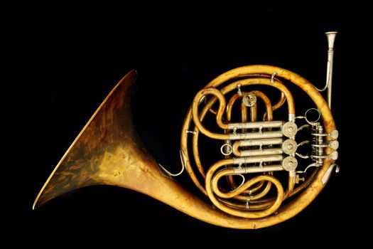 old french horn isolated on the black background