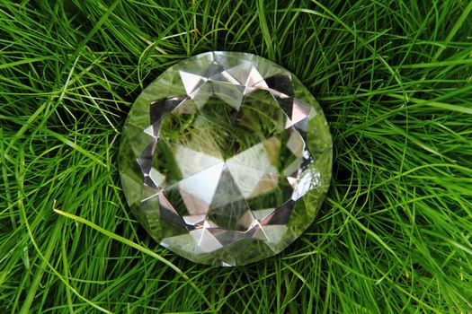 clear diamond in the green grass as luxury background