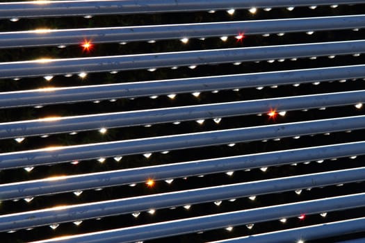 water drops on steel background against sun 