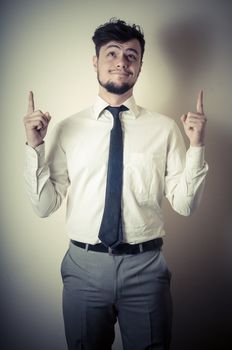 stylish modern guy with white shirt pointing on gray background