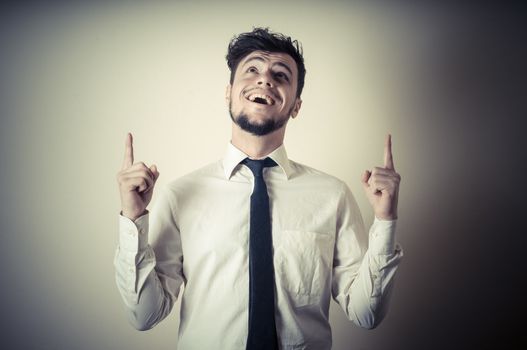 stylish modern guy with white shirt pointing on gray background