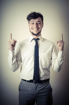 stylish modern guy with white shirt pointing on gray background