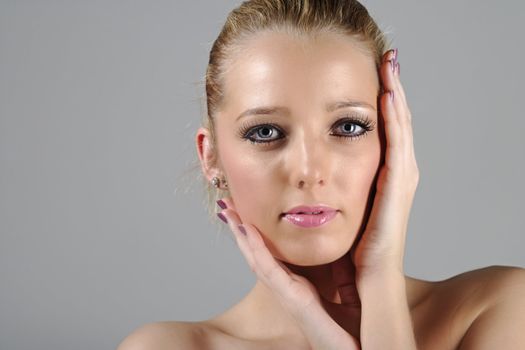 Young woman in a beauty style pose with her hands round her face