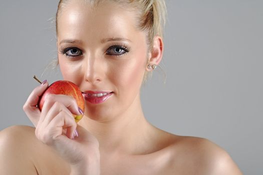 Beautiful young woman in beauty style pose holding an apple