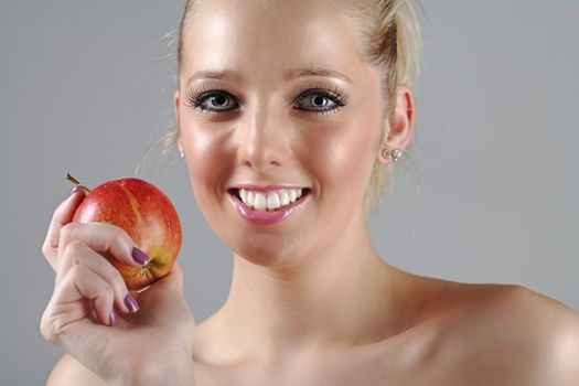 Beautiful young woman in beauty style pose holding an apple