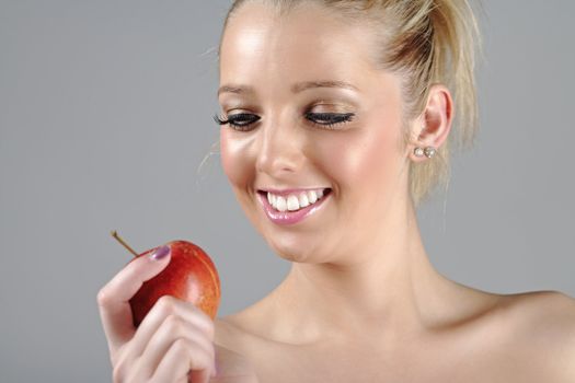 Beautiful young woman in beauty style pose holding an apple