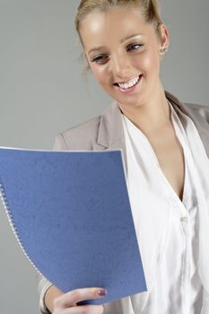Young beautiful woman in a business suit reading documents.
