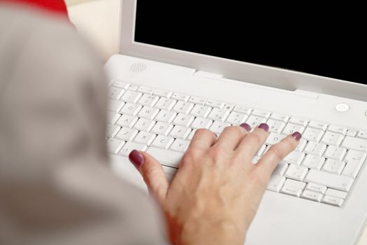 Womans hands typing on laptop keyboard