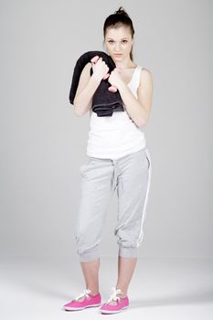 Young woman in fitness wear working out with coloured weights.