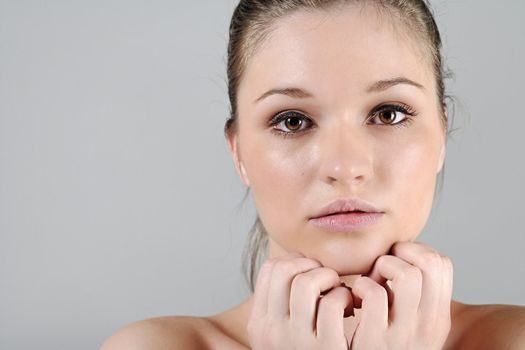 Young woman in a beauty style pose with her hands round her face