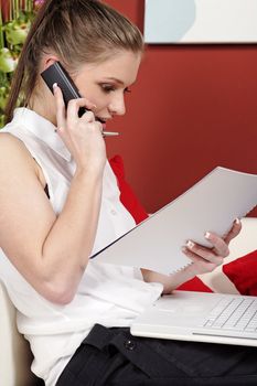 Young woman working from home reading documents