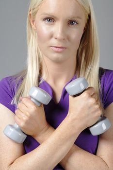 Young woman holding weights and working out