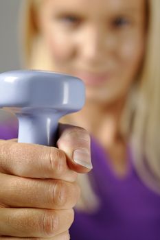 Young woman holding weights and working out