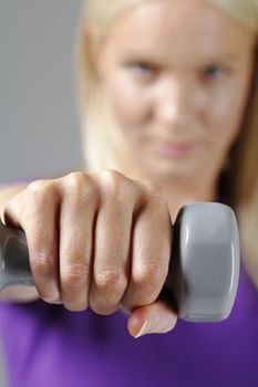 Young woman holding weights and working out