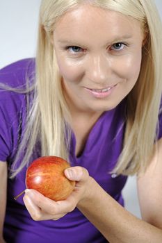 Young woman with an apple and resting after workout.