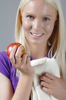 Young woman with an apple and resting after workout.