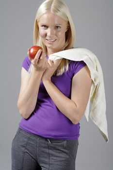 Young woman with an apple and resting after workout.