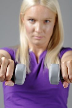 Young woman holding weights and working out