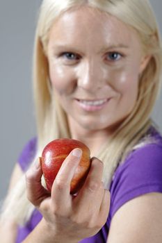 Young woman with an apple and resting after workout.