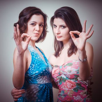 two beautiful girls positive on gray background