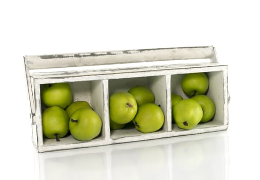 white wooden box with green imitation apples 