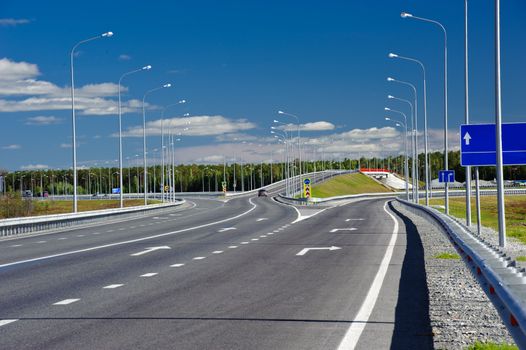 Overpass on the country road. Summer sunny day. Blue sky.