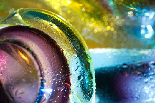 Bright colorful abstract background. Glass and drops of water. Closeup.