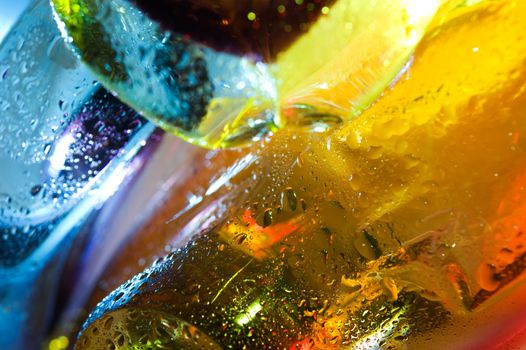 Bright colorful abstract background. Glass and drops of water. Closeup.