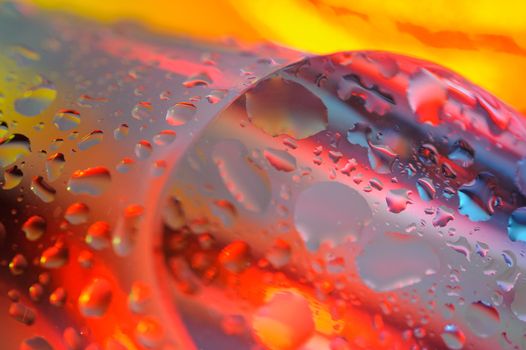 Bright colorful abstract background. Glass and drops of water. Closeup. Shallow depth of field.