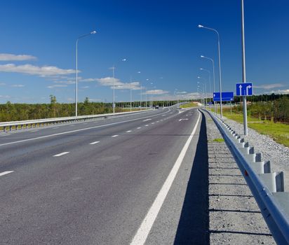 Overpass on the country road. Summer sunny day. Blue sky.