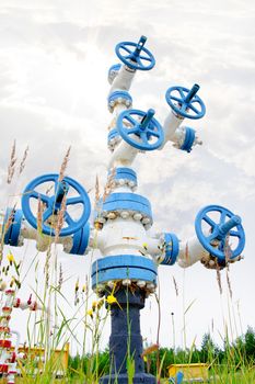 Oil, gas industry. Wellhead with valve armature on a sky background.