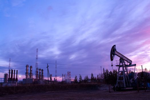 oil pump on  background of  industrial landscape and sunset sky