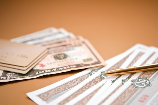 golden pen, money and bank card. closeup. shallow depth of field.