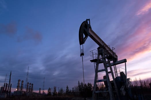 oil pump on  background of  industrial landscape and sunset sky