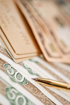 golden pen, money and bank card. closeup. shallow depth of field.