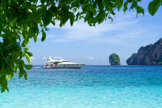 White motor yacht on the background of turquoise water and rocks