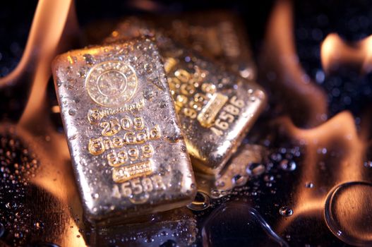 gold bullion and  flame. safe investments.